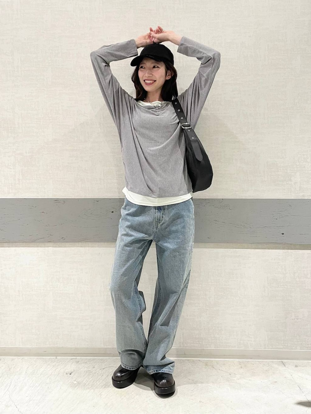 ブラック系のデニムパンツ、ブラック系のショルダーバッグ、グレー系のTシャツ/カットソーを着用したレディースの夏コーディネートの3枚目の写真