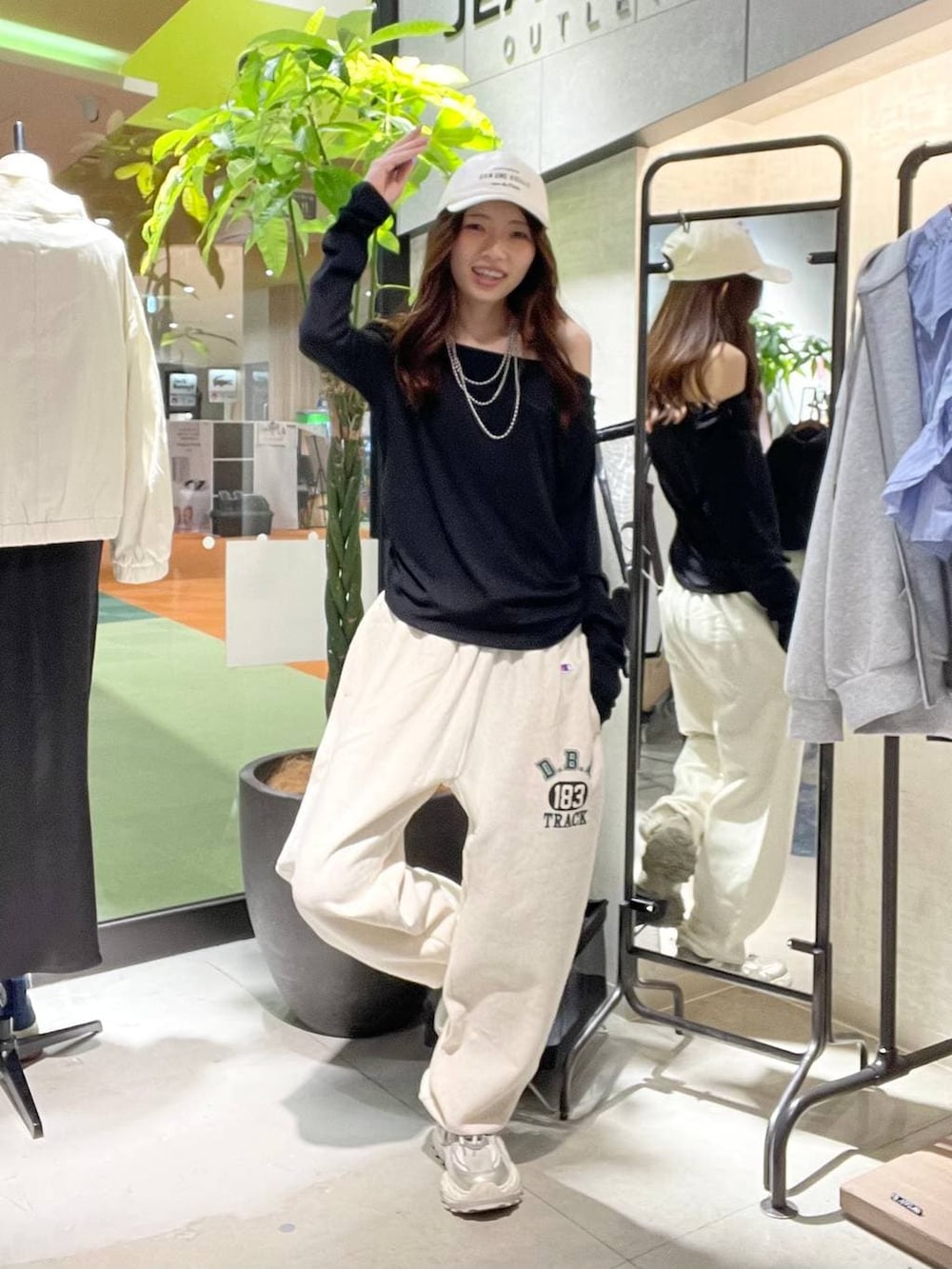 シルバー系のスニーカー、ブラック系のTシャツ/カットソー、ベージュ系のスウェットパンツを着用したレディースの春コーディネートの2枚目の写真