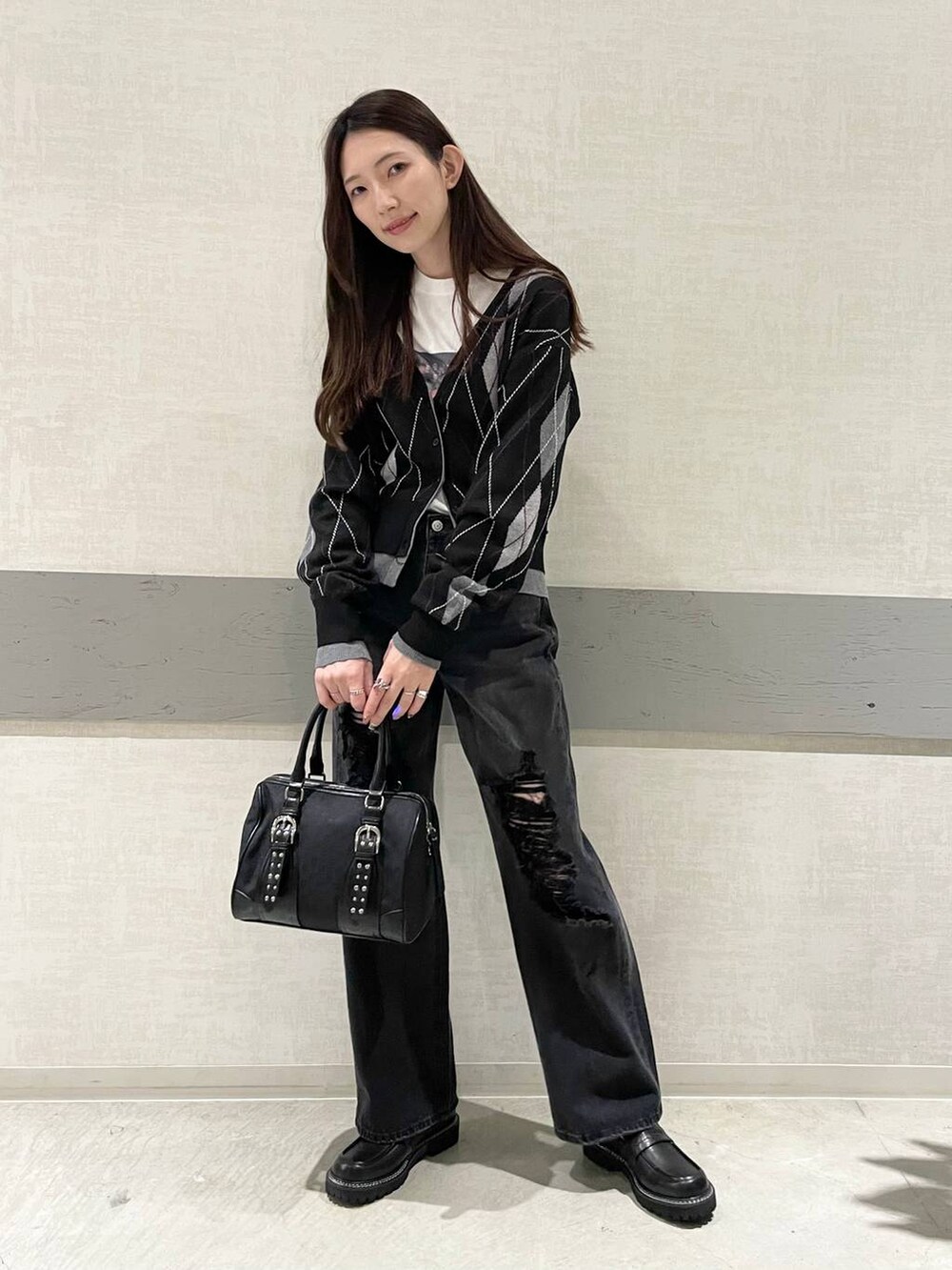ブラック系のボストンバッグ、ブラック系のローファー、ブラック系のデニムパンツを着用したレディースの秋コーディネートの4枚目の写真