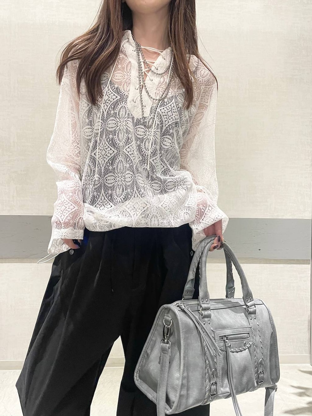 ブラック系のローファー、ブルー系のボストンバッグ、ホワイト系のパーカーを着用したレディースの春コーディネートの4枚目の写真