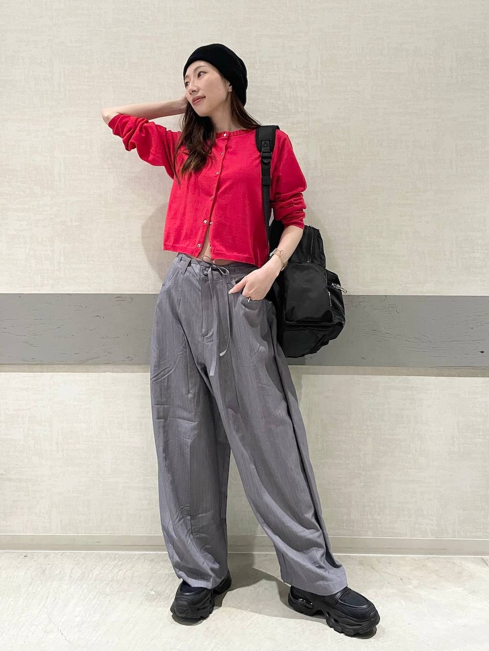 ブラック系のローファー、ブラック系のバックパック/リュック、グレー系のスラックスを着用したレディースの春コーディネートの2枚目の写真