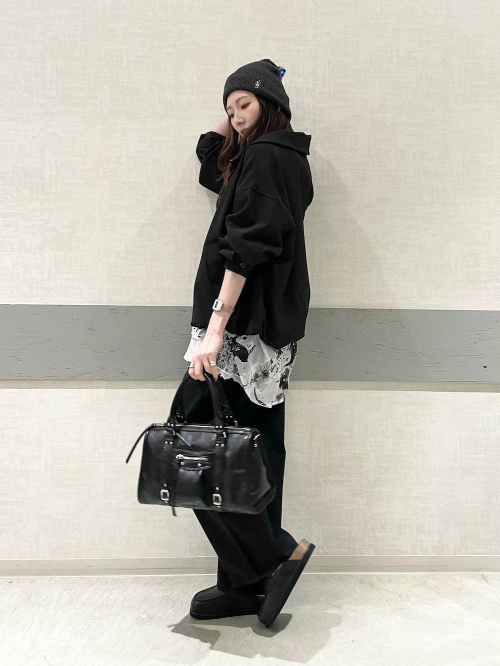 ブラック系のローファー、ブラック系のボストンバッグ、ブラック系のデニムパンツを着用したレディースの春コーディネートの3枚目の写真