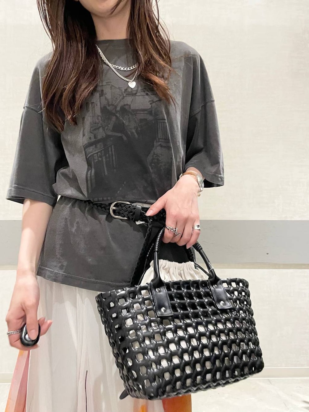 ホワイト系のスカート、ベージュ系のローファー、ブラック系のハンドバッグを着用したレディースの夏コーディネートの5枚目の写真