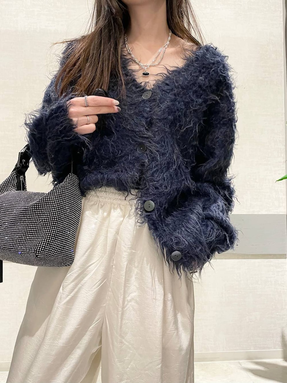 グレー系のパンプス、ブラック系のハンドバッグ、ブルー系のカーディガン/ボレロを着用したレディースの冬コーディネートの5枚目の写真