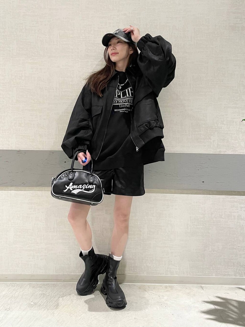 ブラック系のブルゾン、ブラック系のブーツ、ブラック系のショルダーバッグを着用したレディースの秋コーディネートの2枚目の写真