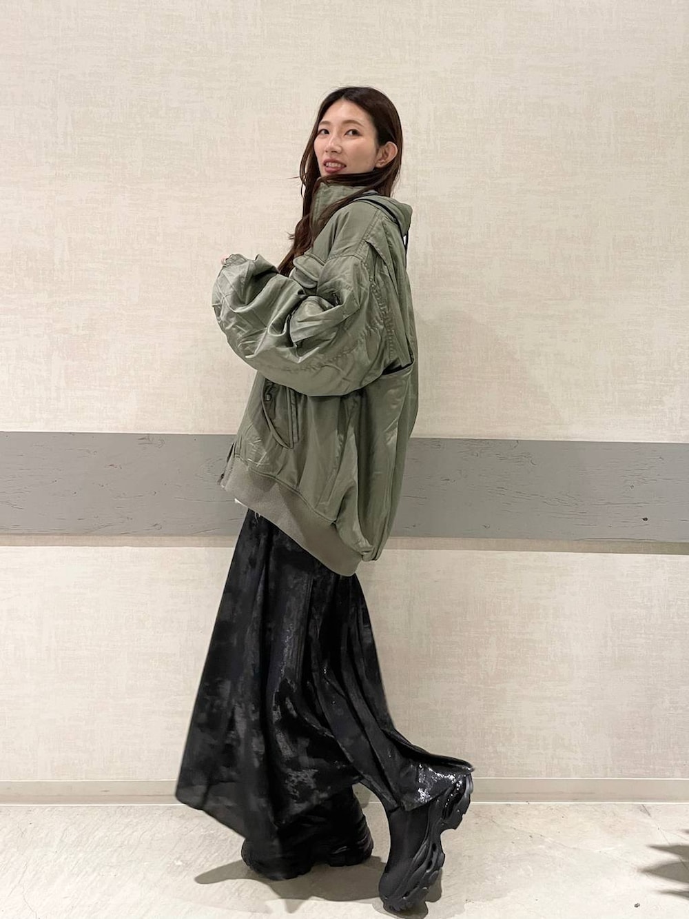 ブラック系のブーツ、グリーン系のブルゾン、ベージュ系のTシャツ/カットソーを着用したレディースの秋コーディネートの2枚目の写真