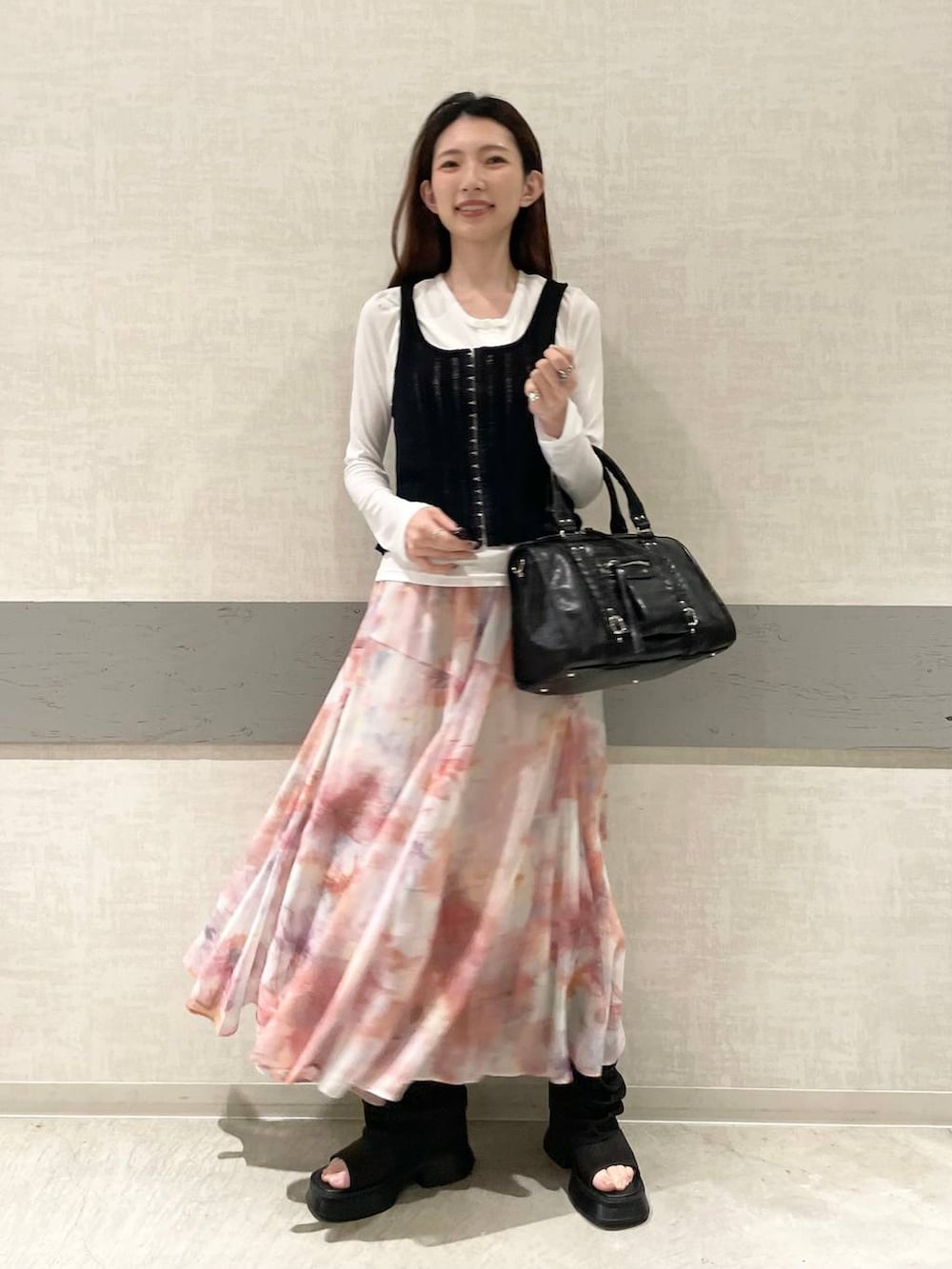 ホワイト系のTシャツ/カットソー、ブラウン系のボストンバッグ、ブラック系のサンダルを着用したレディースの春コーディネートの2枚目の写真