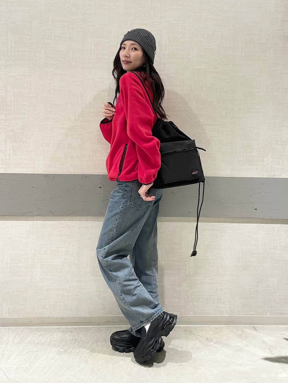 ブルー系のデニムパンツ、レッド系のその他アウター、ブラック系のバックパック/リュックを着用したレディースの秋コーディネートの5枚目の写真