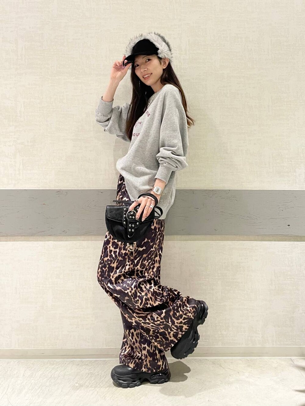 ブラック系のブーツ、ブラック系のショルダーバッグ、グレー系のスウェットを着用したレディースの冬コーディネートの3枚目の写真