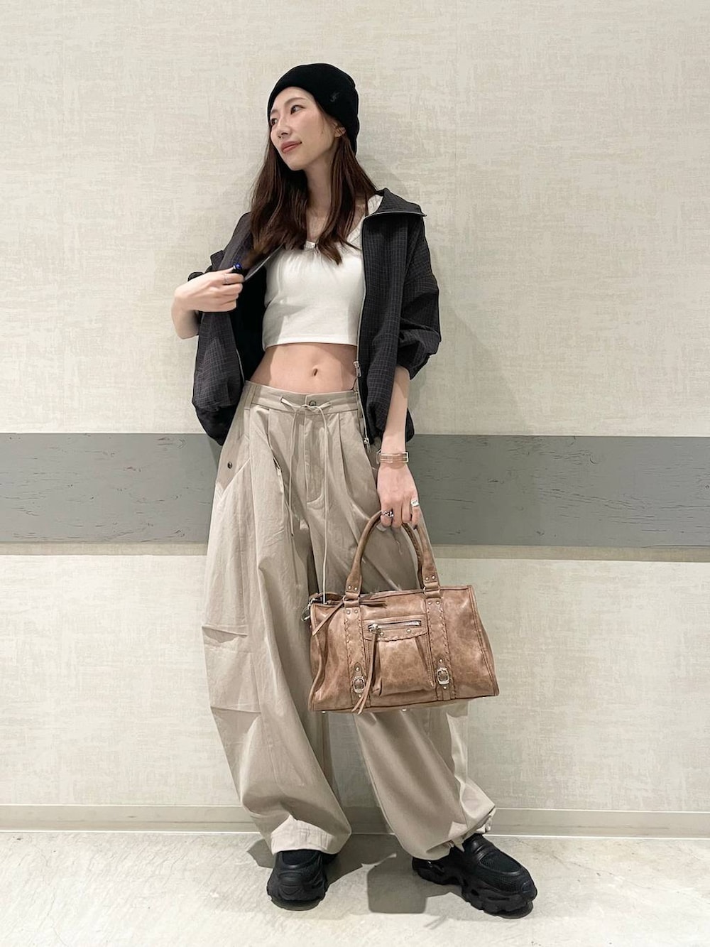 ホワイト系のタンクトップ、ブラック系のローファー、ブラウン系のボストンバッグを着用したレディースの春コーディネートの3枚目の写真