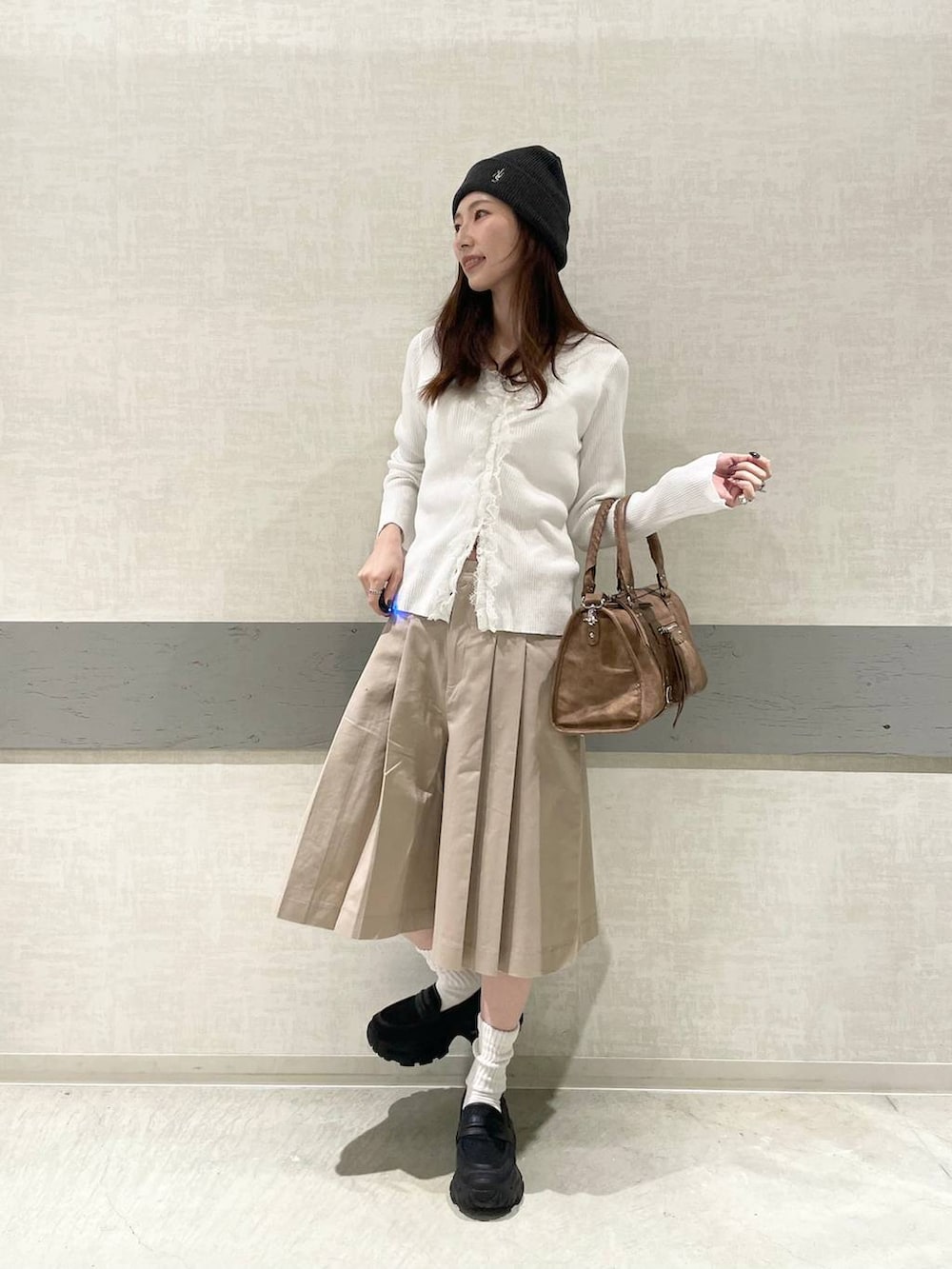 ブラック系のローファー、ブラウン系のボストンバッグ、ベージュ系のその他パンツを着用したレディースの春コーディネートの5枚目の写真