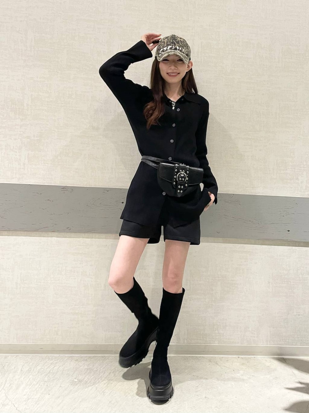 ブラック系のショルダーバッグ、ブラック系のブーツ、ブラック系のセットアップを着用したレディースの冬コーディネートの3枚目の写真