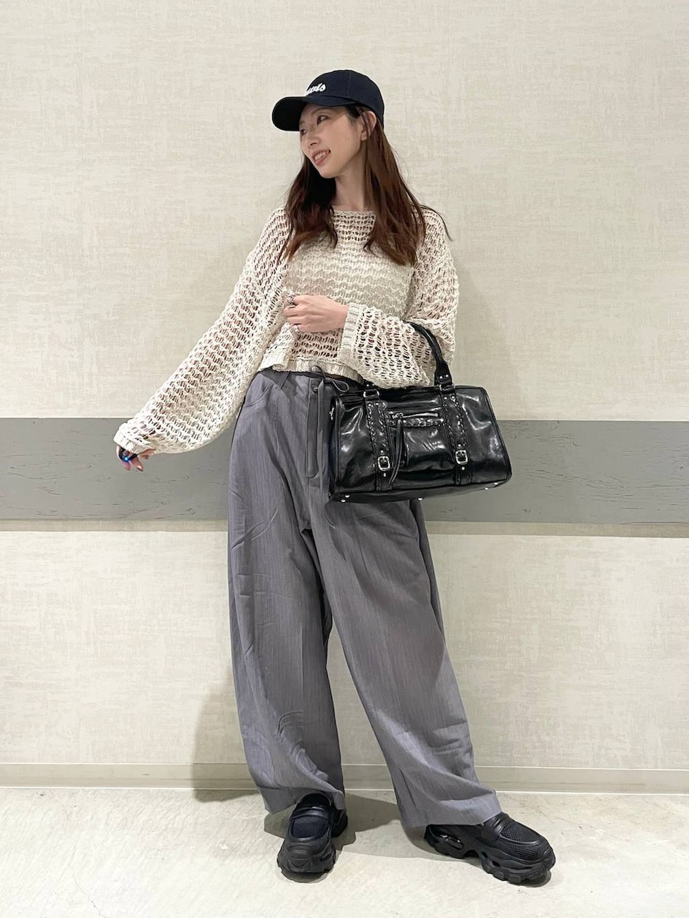 ブラック系のローファー、ブラック系のボストンバッグ、ピンク系のニット/セーターを着用したレディースの春コーディネートの6枚目の写真