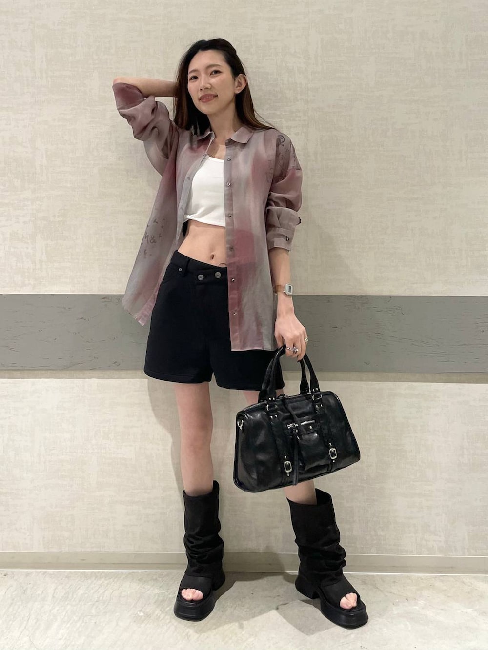 ホワイト系のタンクトップ、ブラック系のスウェットパンツ、ブラック系のボストンバッグを着用したレディースの春コーディネートの4枚目の写真