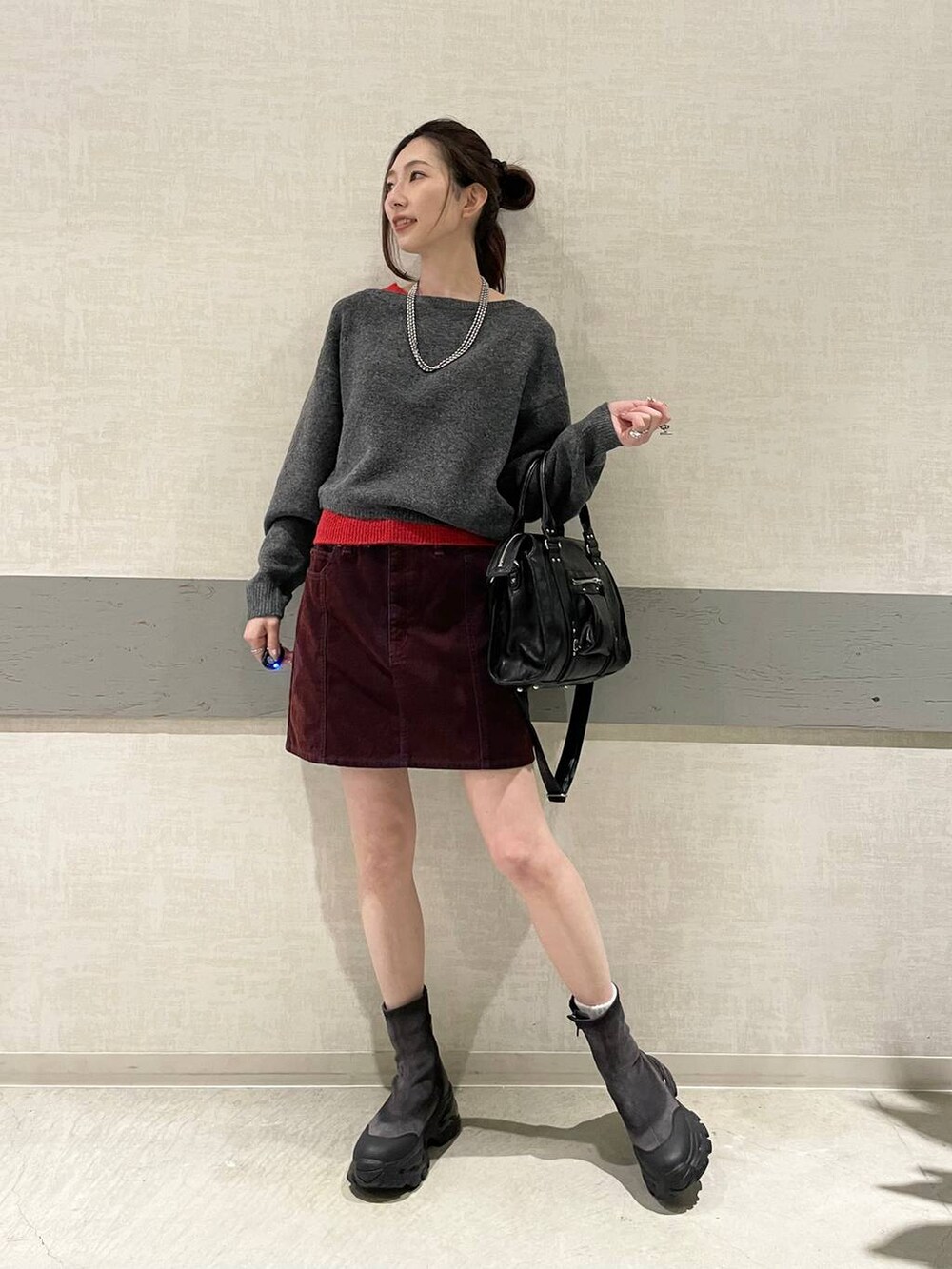 ブラック系のボストンバッグ、グレー系のブーツ、グレー系のニット/セーターを着用したレディースの冬コーディネートの3枚目の写真