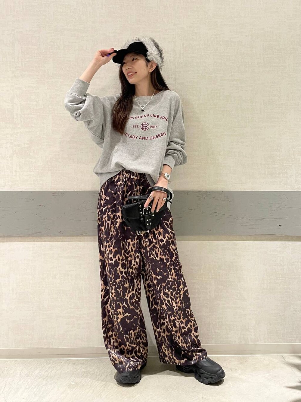 ブラック系のブーツ、ブラック系のショルダーバッグ、グレー系のスウェットを着用したレディースの冬コーディネートの2枚目の写真