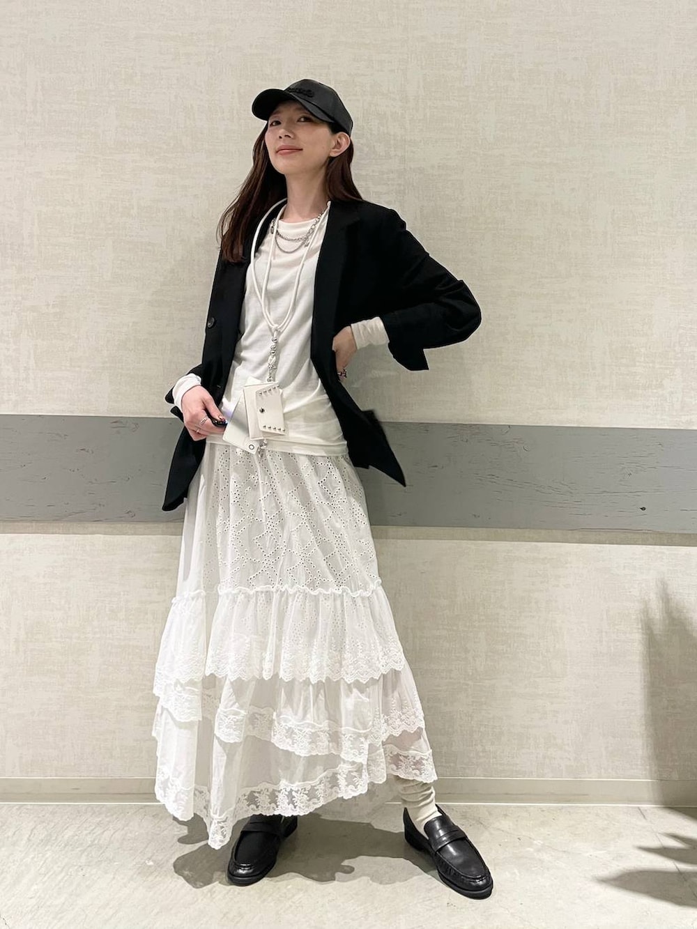 ホワイト系のTシャツ/カットソー、ブラック系のテーラードジャケット、ブラック系のローファーを着用したレディースの冬コーディネートの4枚目の写真