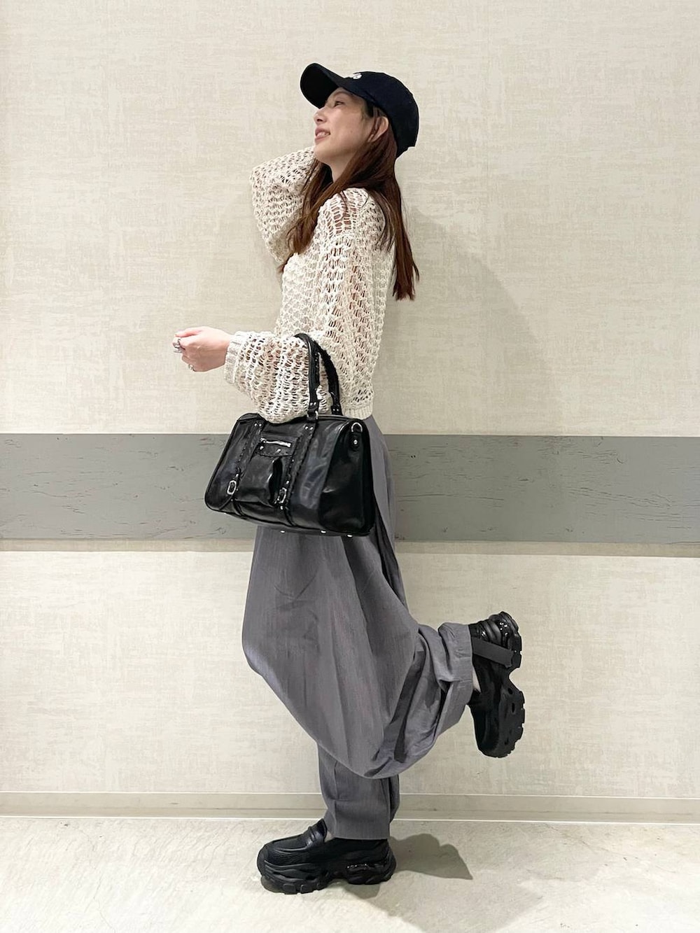 ブラック系のローファー、ブラック系のボストンバッグ、ピンク系のニット/セーターを着用したレディースの春コーディネートの4枚目の写真