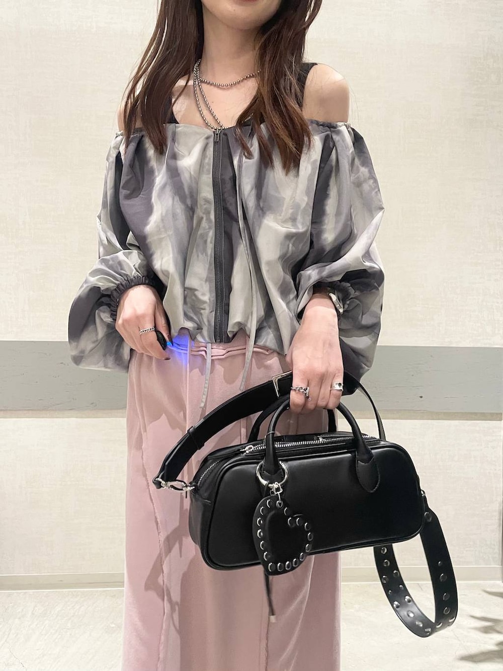 ブラック系のボストンバッグ、ベージュ系のローファー、ピンク系のスカートを着用したレディースの春コーディネートの6枚目の写真