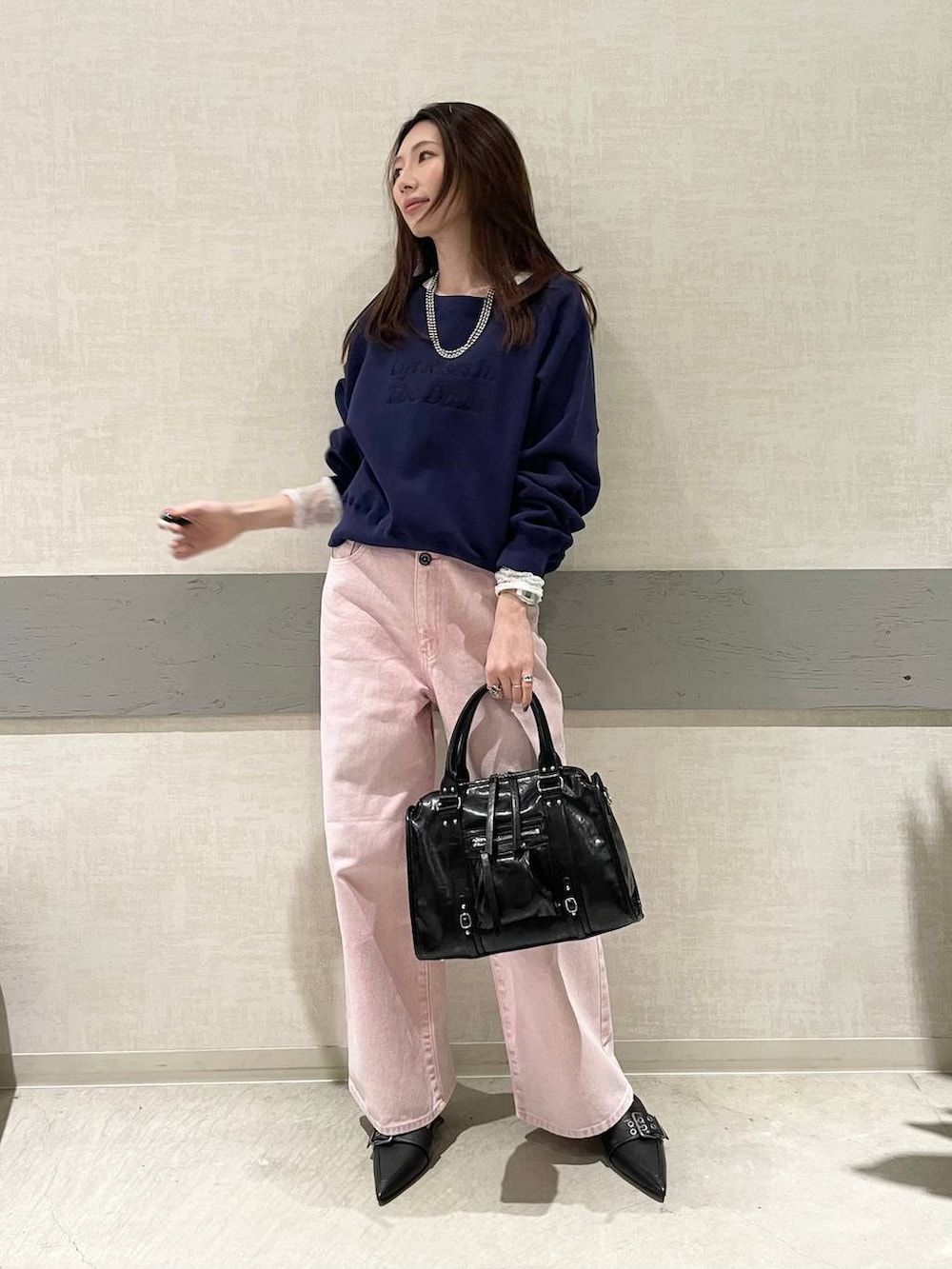 ブラック系のボストンバッグ、ブラック系のパンプス、ホワイト系のTシャツ/カットソーを着用したレディースの冬コーディネートの3枚目の写真