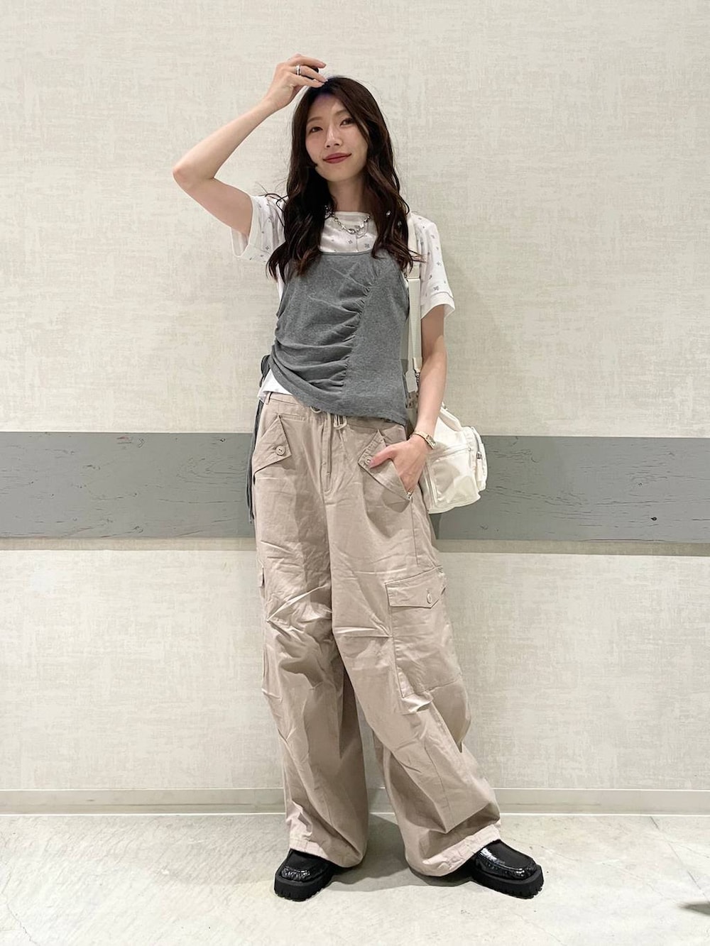 ブラック系のローファー、ホワイト系のTシャツ/カットソー、ホワイト系のトートバッグを着用したレディースの夏コーディネートの2枚目の写真