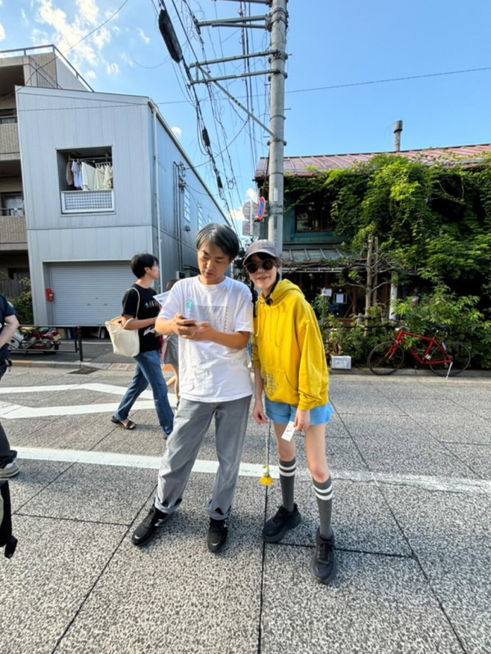 ブルー系のその他パンツ、イエロー系のパーカー、グレー系のキャップを着用したレディースの秋コーディネートの2枚目の写真