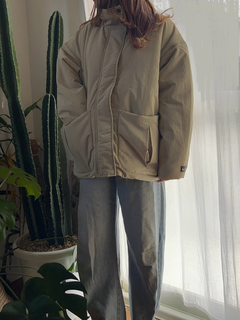 ベージュ系のブルゾンを着用したレディースの冬コーディネートの3枚目の写真