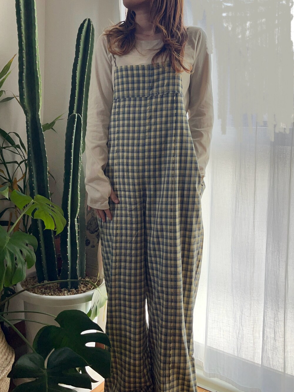 イエロー系のサロペット/オーバーオール、ベージュ系のTシャツ/カットソーを着用したレディースの冬コーディネートの2枚目の写真