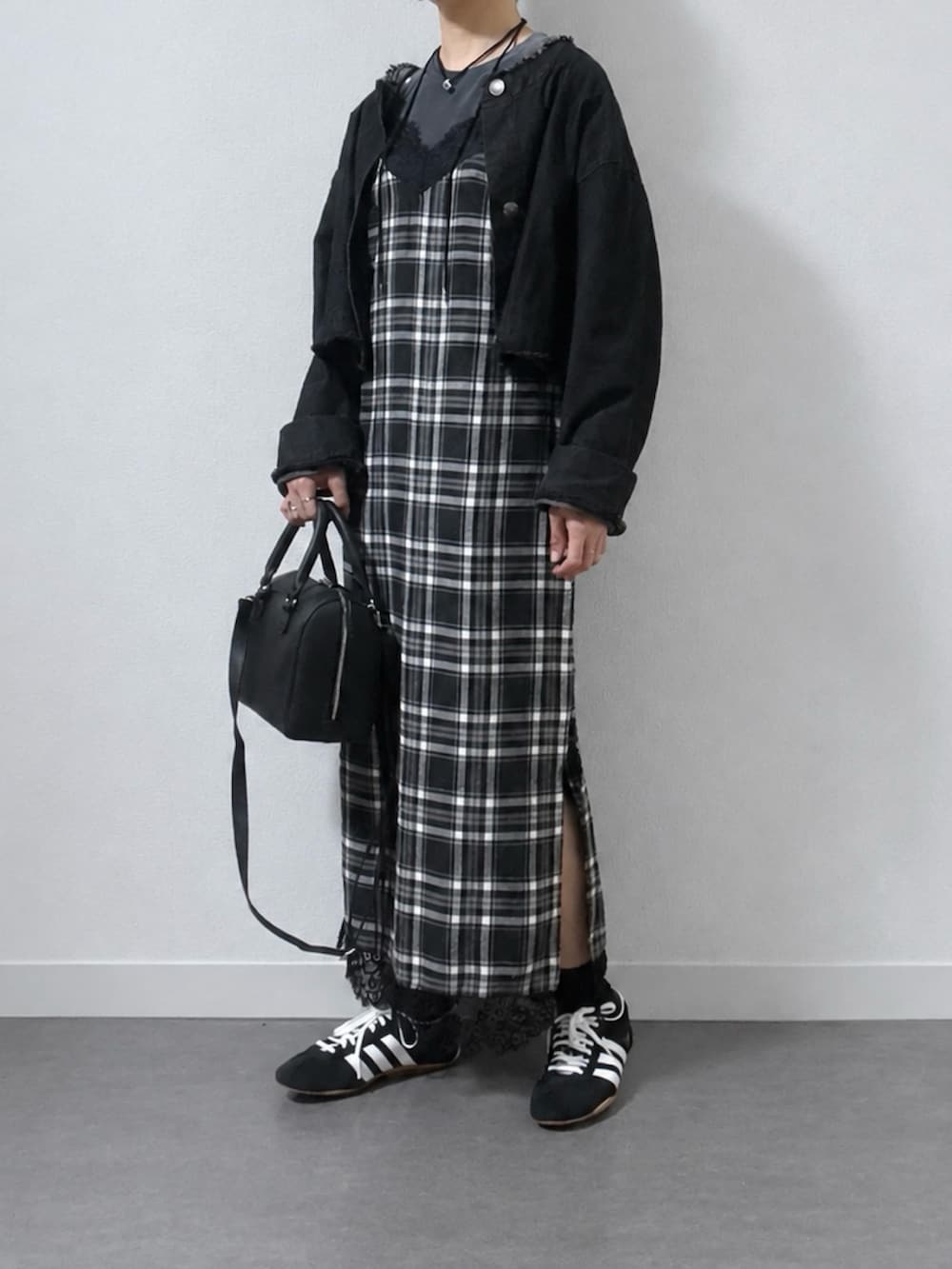ブラック系のデニムジャケット、ブラック系のスニーカー、グレー系のTシャツ/カットソーを着用したレディースの秋コーディネートの2枚目の写真