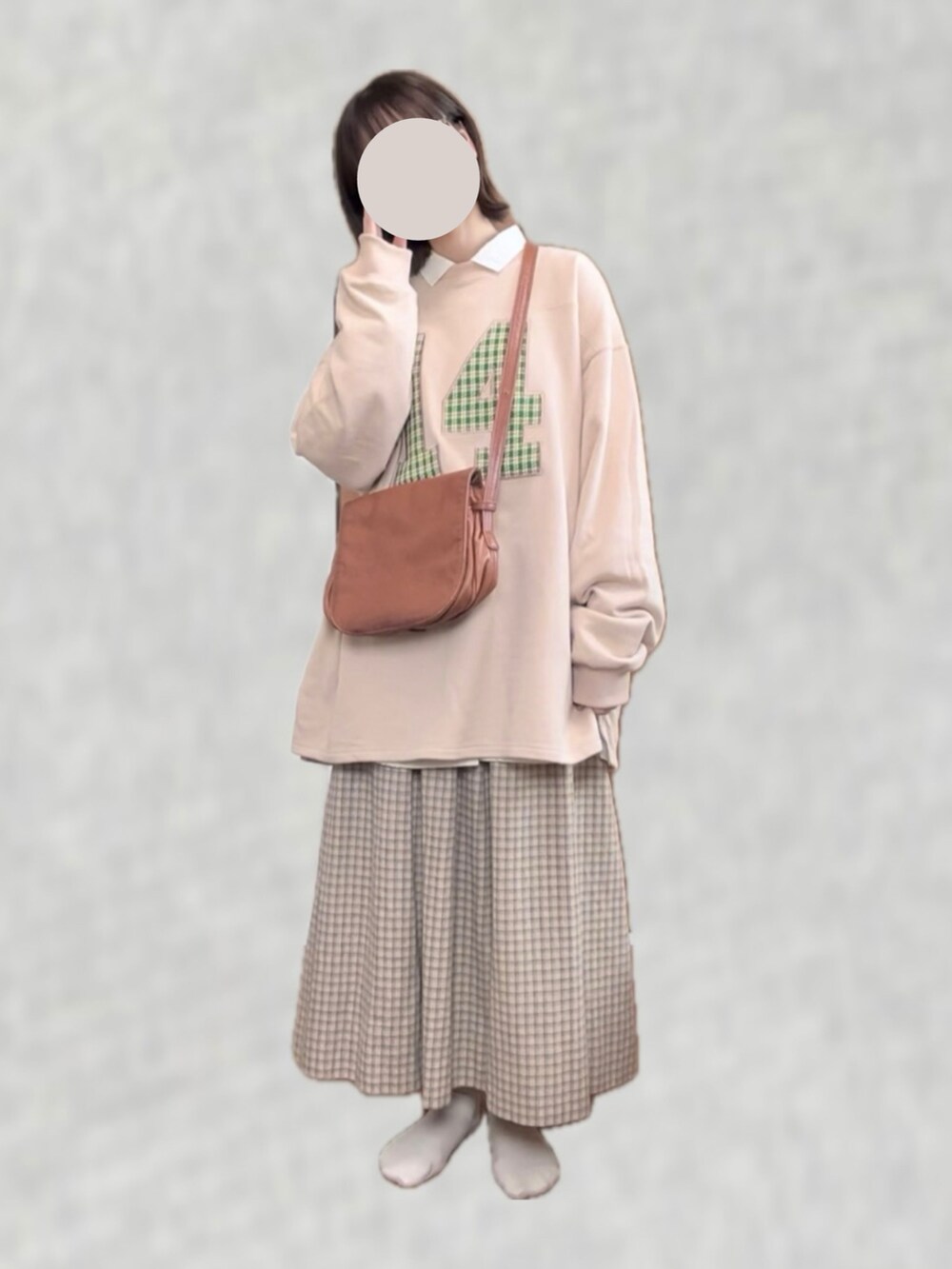 ピンク系のスウェット、ブラウン系のショルダーバッグ、ベージュ系のスカートを着用したレディースの春コーディネートの2枚目の写真