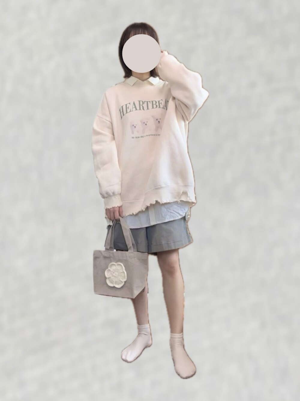 ホワイト系のスウェット、グリーン系のパンツ、ベージュ系のハンドバッグを着用したレディースの春コーディネートの2枚目の写真