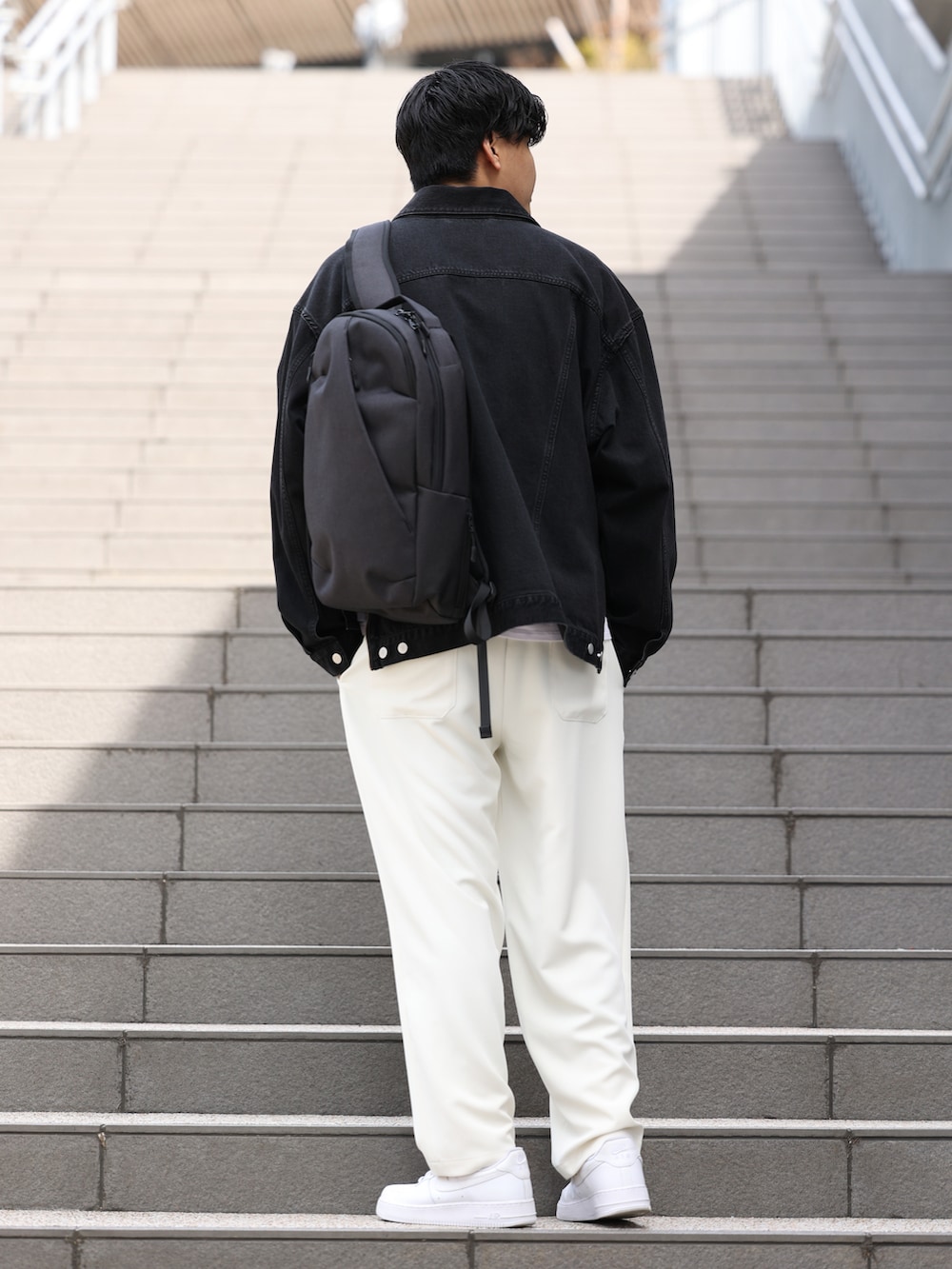 ブラック系のデニムジャケット、グレー系のTシャツ/カットソー、ホワイト系のスニーカーを着用したメンズの春コーディネートの2枚目の写真