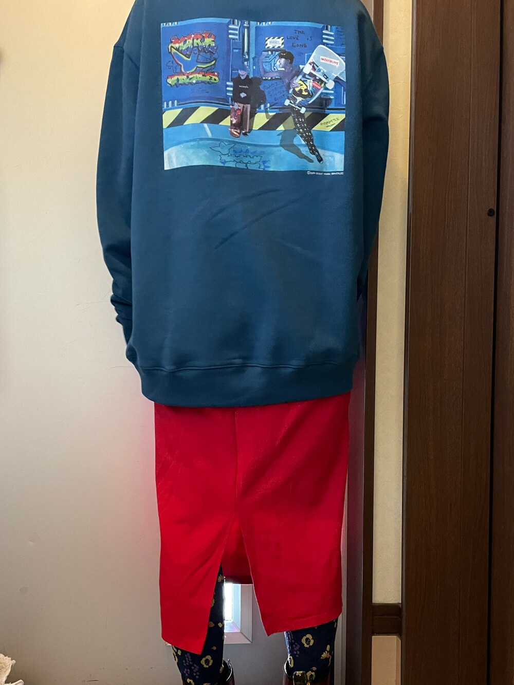 ブルー系のトップス、レッド系のスカート、グリーン系のブーツを着用したレディースの秋コーディネートの2枚目の写真