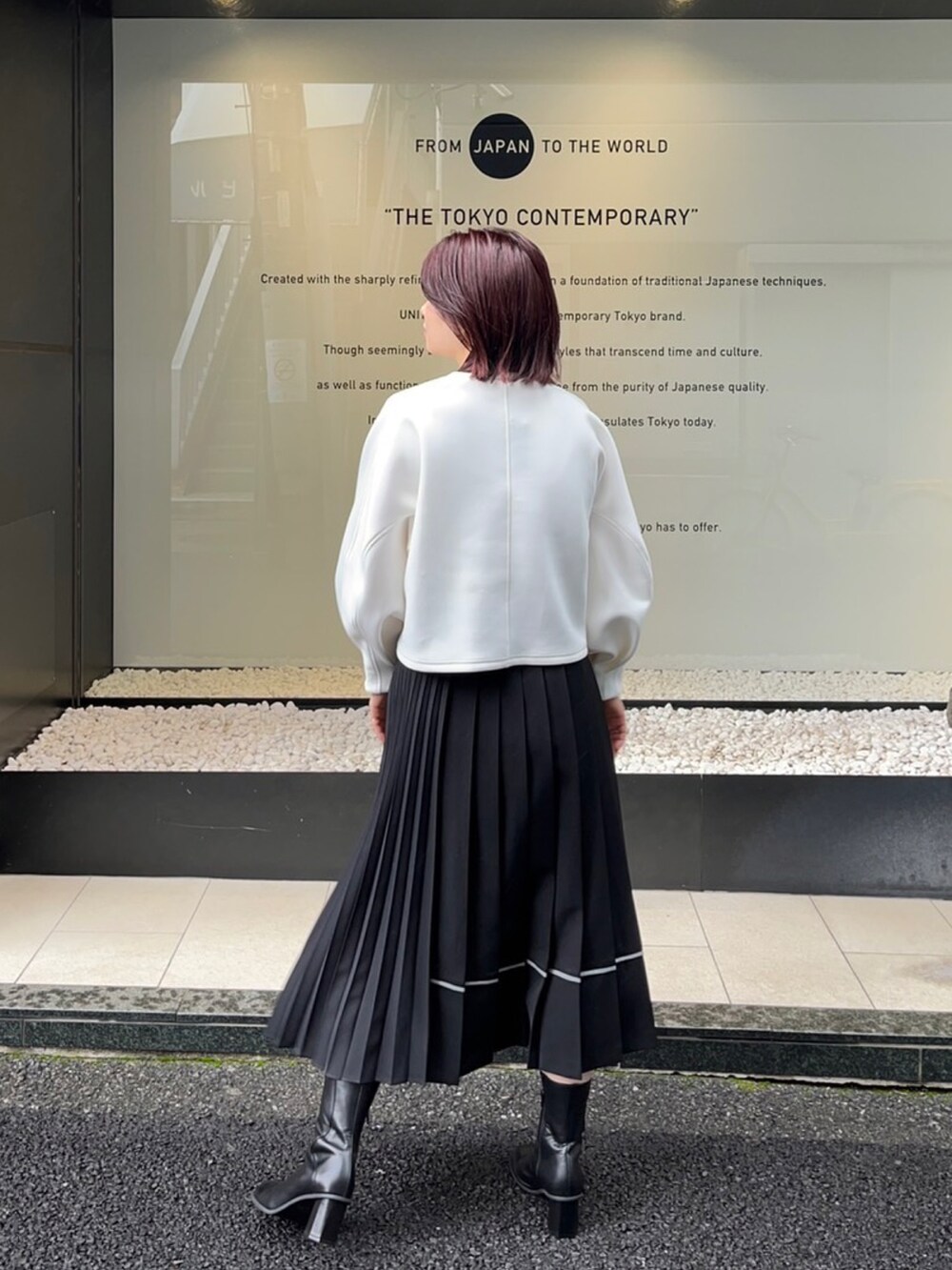ホワイト系のスウェット、ブラック系のスカートを着用したレディースの秋コーディネートの2枚目の写真
