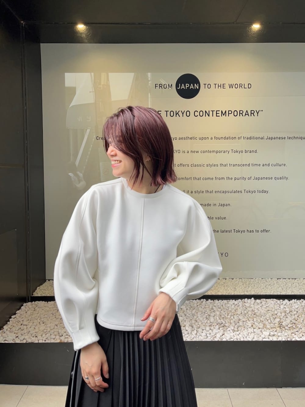 ホワイト系のスウェット、ブラック系のスカートを着用したレディースの秋コーディネートの3枚目の写真