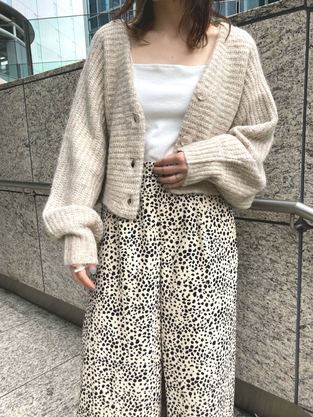 ベージュ系のカーディガン/ボレロ、ホワイト系のキャミソール、ブラック系のショルダーバッグを着用したレディースの夏コーディネートの3枚目の写真