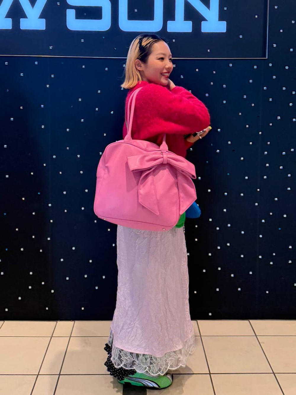 ピンク系のボストンバッグを着用したレディースの冬コーディネートの2枚目の写真