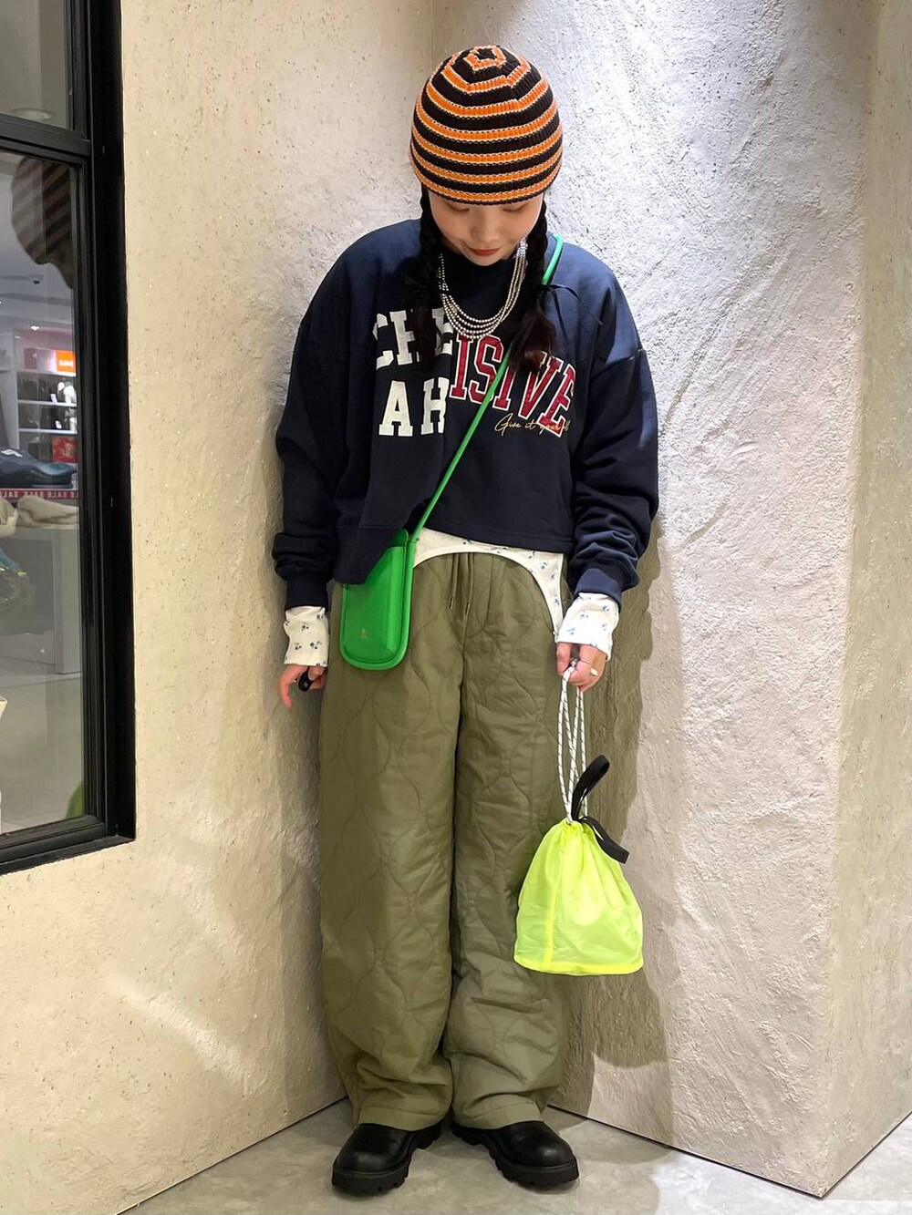 グリーン系のその他パンツ、ブラック系のブーツ、イエロー系のショルダーバッグを着用したレディースの冬コーディネートの2枚目の写真