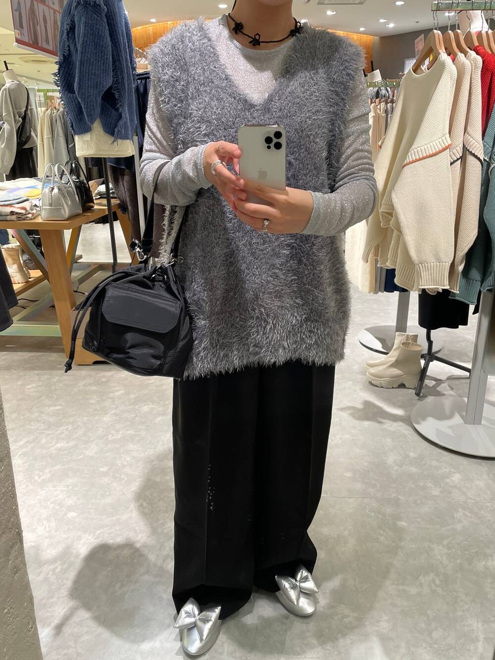 ブラック系のスラックス、グレー系のベスト、ブラック系のショルダーバッグを着用したレディースの秋コーディネートの7枚目の写真