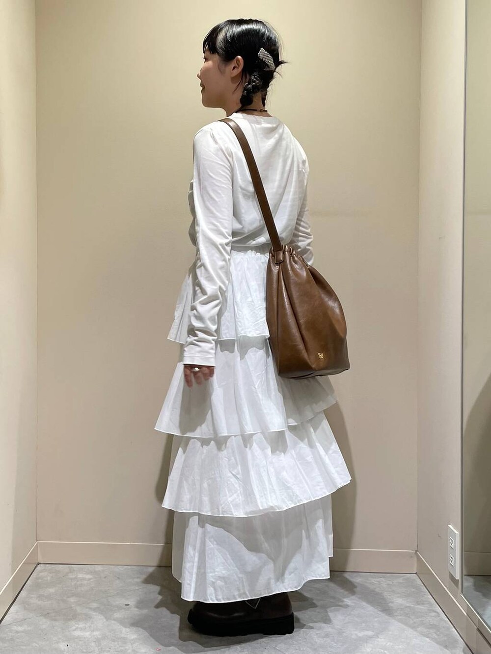 グリーン系のその他アウター、ブラウン系のブーツ、ホワイト系のスカートを着用したレディースの秋コーディネートの6枚目の写真