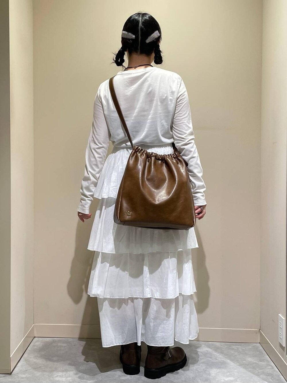 グリーン系のその他アウター、ブラウン系のブーツ、ホワイト系のスカートを着用したレディースの秋コーディネートの7枚目の写真