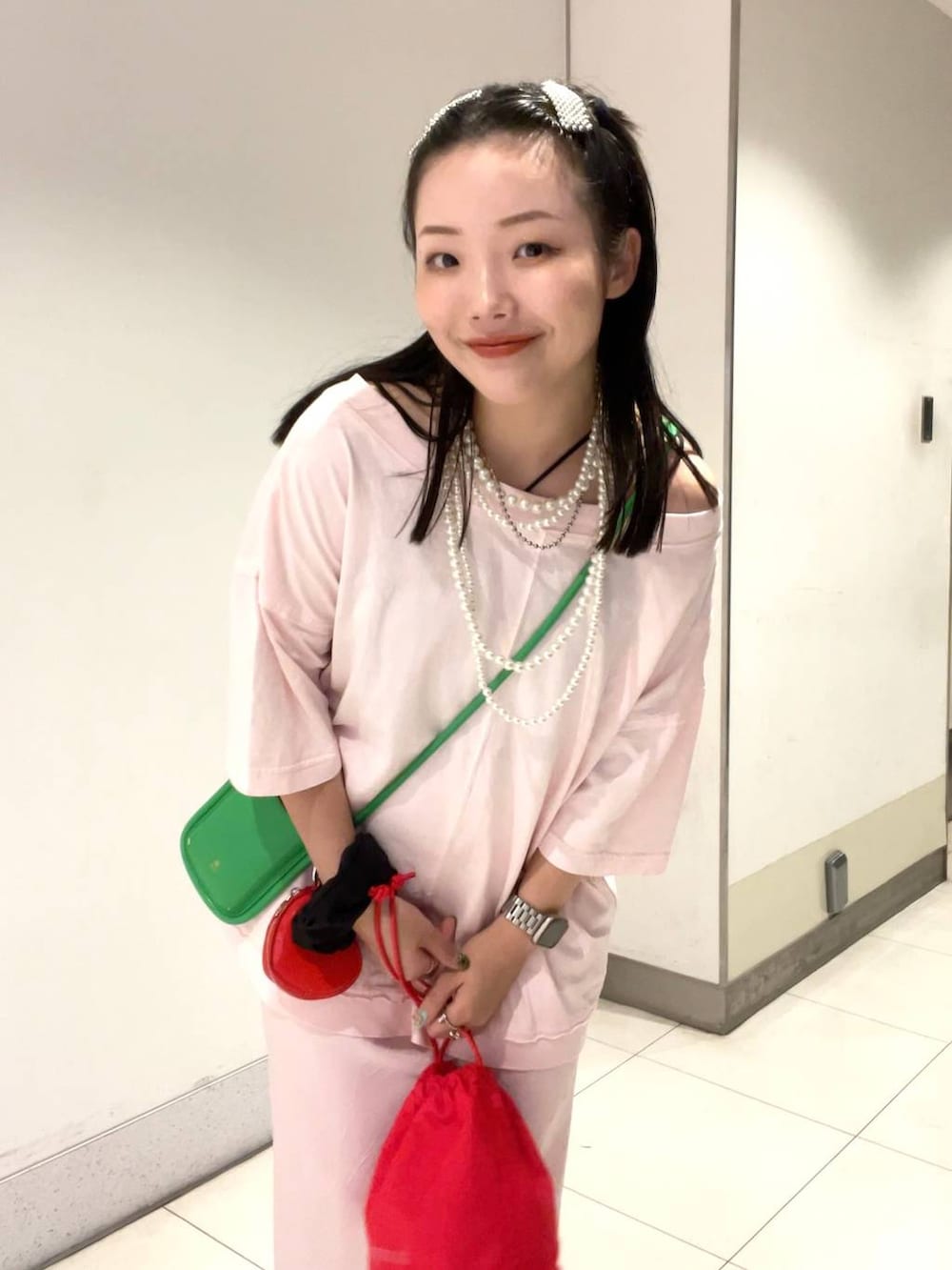 レッド系のサンダル、ブラック系のキャミソール、ピンク系のスカートを着用したレディースの夏コーディネートの6枚目の写真