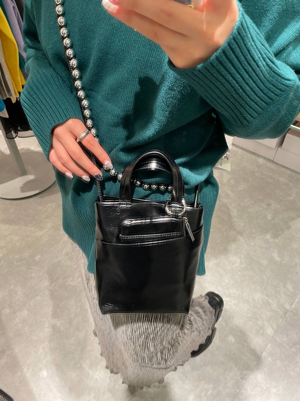 ブラック系のブーツ、ブルー系のその他パンツ、グリーン系のニット/セーターを着用したレディースの冬コーディネートの3枚目の写真