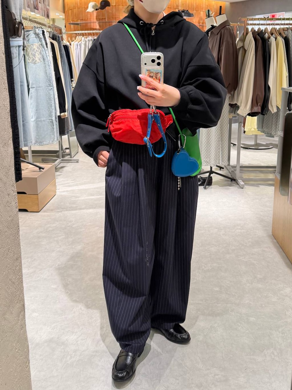 ブルー系のその他パンツ、ブラック系のパーカー、レッド系のボディバッグ/ウエストポーチを着用したレディースの冬コーディネートの3枚目の写真