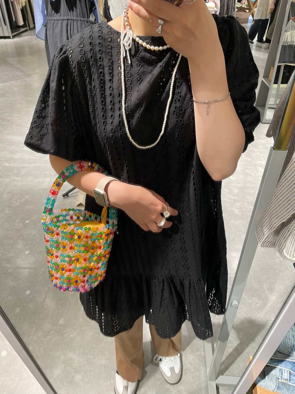 ホワイト系のスニーカー、ベージュ系のその他パンツ、その他のハンドバッグを着用したレディースの夏コーディネートの6枚目の写真