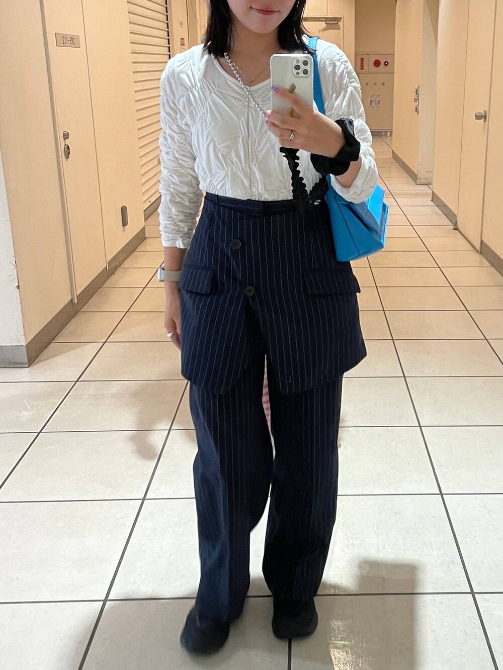 ブルー系のスラックス、その他のイヤリング、シルバー系のリングを着用したレディースの秋コーディネートの7枚目の写真