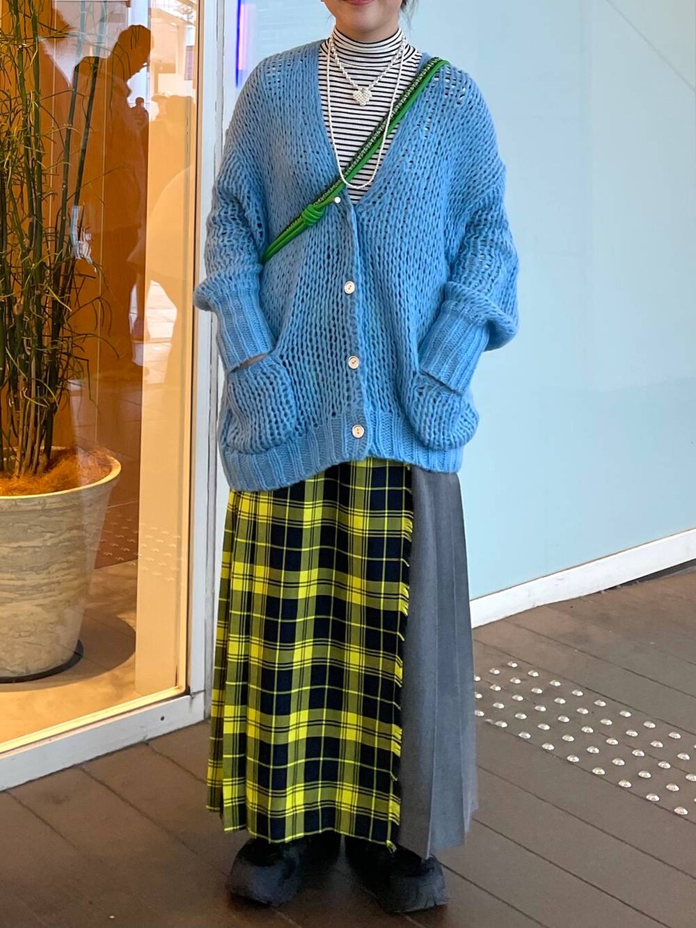 ホワイト系のTシャツ/カットソー、イエロー系のスカート、ブルー系のカーディガン/ボレロを着用したレディースの春コーディネートの2枚目の写真