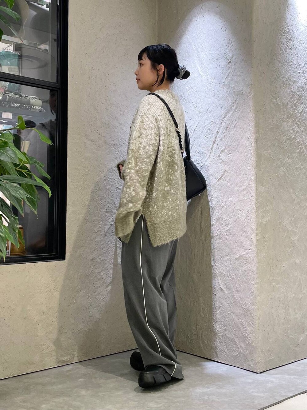 ブラック系のブーツ、グレー系のその他パンツ、グリーン系のニット/セーターを着用したレディースの秋コーディネートの3枚目の写真