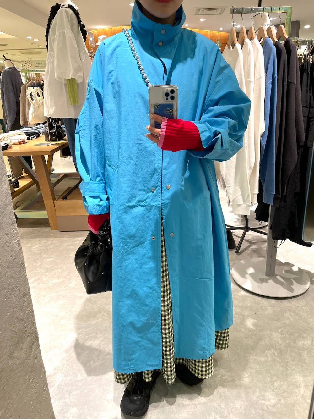 ブラック系のハンドバッグ、グリーン系のワンピース、ブルー系のブルゾンを着用したレディースの春コーディネートの5枚目の写真