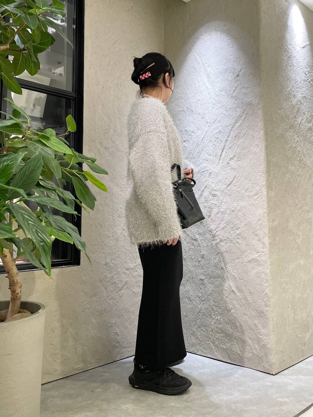 ブラック系のショルダーバッグ、グレー系のカーディガン/ボレロ、グレー系のTシャツ/カットソーを着用したレディースの秋コーディネートの5枚目の写真